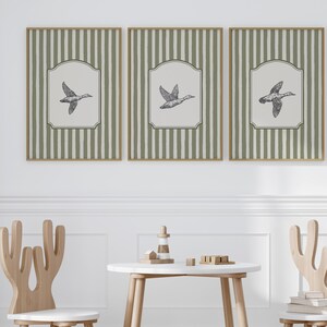 Peut inclure: Ensemble de trois impressions encadr&eacute;es avec une illustration vintage d'un canard en vol. Chaque &oelig;uvre pr&eacute;sente un fond cr&egrave;me dans un cadre d&eacute;coratif, sur un motif &agrave; rayures vertes et blanches. Les cadres sont de couleur marron clair.