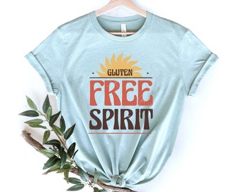 May include: A light blue t-shirt with a sun graphic and the text "Gluten Free Spirit" in a vintage style font.