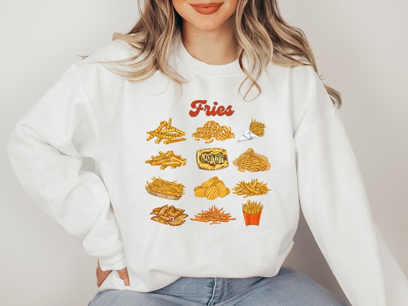 Pu&ograve; includere: Felpa bianca con la parola "Fries" in lettere rosse e una variet&agrave; di patatine fritte illustrate in giallo e marrone.