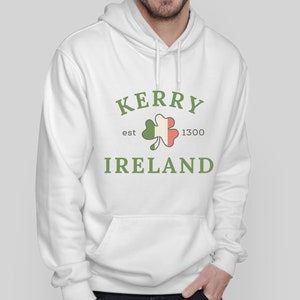 Op de afbeelding: Witte hoodie met een groene klaver en de tekst "Kerry est 1300 Ierland" gedrukt op de voorkant.