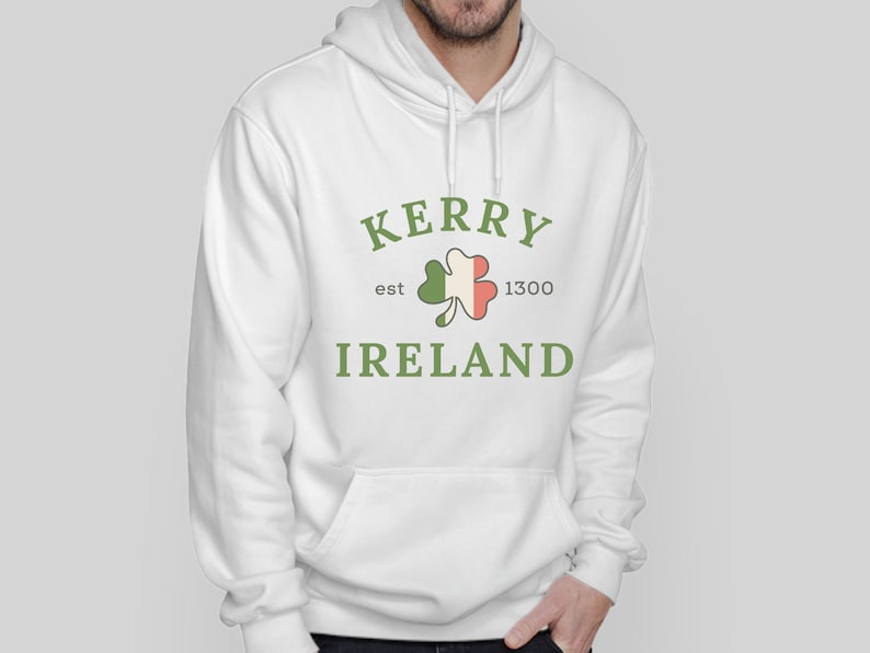 Op de afbeelding: Witte hoodie met een groene klaver en de tekst "Kerry est 1300 Ierland" gedrukt op de voorkant.