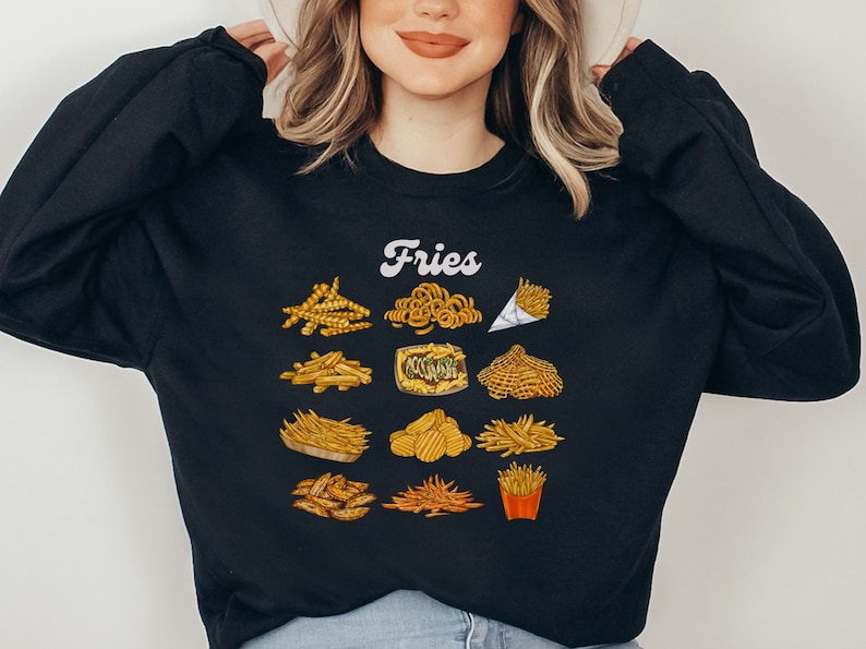 Pu&ograve; includere: Felpa nera con la parola "Fries" in lettere bianche e una variet&agrave; di diversi tipi di patatine fritte illustrate in giallo e marrone.