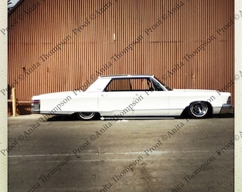 Chrysler White classic sedan lowered against a red wall