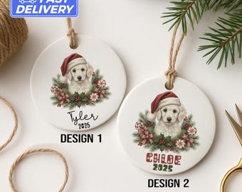Peut inclure: Deux décorations de Noël rondes en céramique blanche. Chaque ornement présente un chiot golden retriever portant un bonnet de Père Noël, entouré d'une couronne de verdure et de cannes en bonbon. L'un dit "Tyler 2025" et l'autre "Chloe 2025".