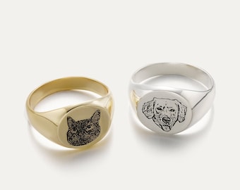 May include: Two signet rings with engraved images of a cat and a dog. The cat ring is gold and the dog ring is silver.