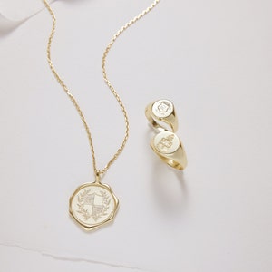 Peut inclure: Un collier en or avec un pendentif repr&eacute;sentant un blason d&eacute;taill&eacute;. Deux bagues signet en or avec des motifs grav&eacute;s sont &eacute;galement repr&eacute;sent&eacute;es.