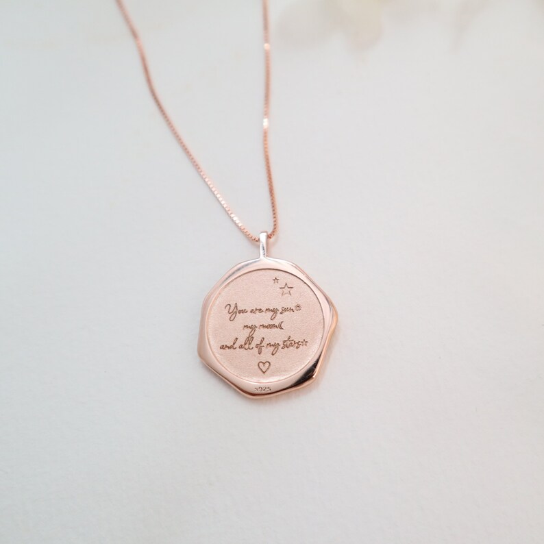 May include: Rose gold necklace with a pendant that reads "You are my sun, my moon, and all of my stars" with a small star and heart engraved on the pendant.