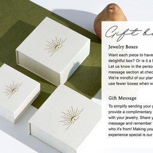 Peut inclure: Trois bo&icirc;tes cadeaux blanches avec un motif soleil et lune. Les bo&icirc;tes sont sur une surface verte. Le texte sur le c&ocirc;t&eacute; droit de l'image se lit comme suit : "Gift box Bo&icirc;tes &agrave; bijoux Voulez-vous que chaque pi&egrave;ce ait sa propre bo&icirc;te charmante ? Ou est-ce un cadeau sinc&egrave;re ? Faites-le nous savoir dans la section personnalisation ou message lors du paiement. Nous sommes conscients de notre plan&egrave;te et visons &agrave; utiliser moins de bo&icirc;tes lorsque nous le pouvons. Message cadeau Pour simplifier l'envoi de votre cadeau, nous fournissons une carte cadeau gratuite avec vos bijoux. Partagez votre message et n'oubliez pas de nous dire de qui il vient ! Faire de votre exp&eacute;rience de cadeaux un moment sp&eacute;cial est notre joie."