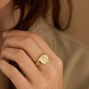 Peut inclure: Une bague signet en or avec un design de blason d&eacute;taill&eacute;.