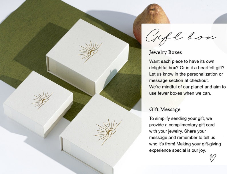 May include: Three white gift boxes with a sun and moon logo. The boxes are made of a textured paper and have a subtle gold color. The text on the image reads "Gift box", "Jewelry Boxes", "Want each piece to have its own delightful box? Or is it a heartfelt gift? Let us know in the personalization or message section at checkout. We're mindful of our planet and aim to use fewer boxes when we can." and "Gift Message", "To simplify sending your gift, we provide a complimentary gift card with your jewelry. Share your message and remember to tell us who it's from! Making your gift-giving experience special is our joy."