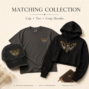May include: A matching collection featuring a charcoal gray baseball cap, a charcoal gray t-shirt, and a black cropped hoodie. Each item displays an embroidered moth graphic with a skull pattern. Text reads MATCHING COLLECTION Cap &bull; Tee &bull; Crop Hoodie.