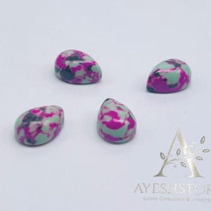 May include: Four teardrop-shaped gemstones with a speckled pattern of magenta, light green, and black. The gemstones are smooth and polished, with a glossy finish. The gemstones are loose and ready for jewelry making.