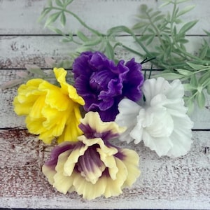 May include: Four artificial flowers with green stems. The flowers are yellow, purple, white, and a combination of purple and yellow.