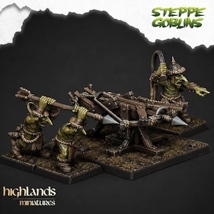 Könnte beinhalten: Drei grünhäutige Goblin-Miniaturen bedienen eine hölzerne Balliste. Zwei Goblins halten einen langen Speer, während ein dritter hinter der Waffe steht. Sie tragen braune, fellbesetzte Rüstungen und Seilgürtel. Der Text STEPPE GOBLINS ist zu sehen.