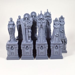 Puede incluir: Colecci&oacute;n de estatuas grises en miniatura, cada una con dise&ntilde;os intrincados de t&uacute;nicas detalladas y bases arquitect&oacute;nicas. Las estatuas var&iacute;an en forma, representando figuras con cascos, capuchas y atuendos ornamentados, adecuadas para juegos de mesa o exhibici&oacute;n.