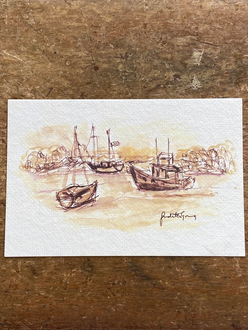 May include: A sepia-toned watercolor painting of boats in a harbor. The artwork features three boats with masts and a small fishing boat. The artist's signature, "Judith Gray," is visible in the lower right corner.
