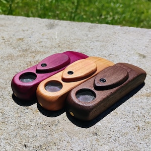 May include: A white ceramic mug with a black handle and the text "But first, coffee" in a black, bold font. The mug is sitting on a wooden surface.