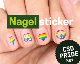 Op de afbeelding: Een set nagelstickers met regenboogkleurige ontwerpen, waaronder een bliksemschicht, in elkaar grijpende vrouwensymbolen, een hart en een vredesteken. De tekst Nagel sticker en CSD PRIDE Set is zichtbaar op de afbeelding over de nagels.