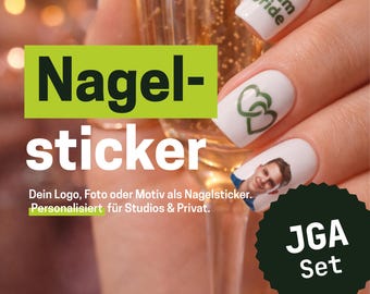 Op de afbeelding: Witte nagelstickers met groene tekst team bride, een groen dubbel hartmotief en een kleine portretfoto. De stickers zijn aangebracht op vingernagels, met Duitse tekstoverlays zoals Nagel-sticker en JGA Set in de afbeelding.