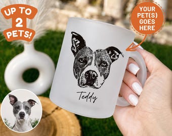 May include: A frosted glass mug featuring a black and white line art illustration of a dog's face with the name Teddy printed in a cursive script below the portrait. The mug has a handle on the right side and a smooth, semi-translucent finish.