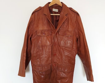 May include: A brown leather jacket with a button-up front, four pockets, and a label that reads "Hide'n'Seek".