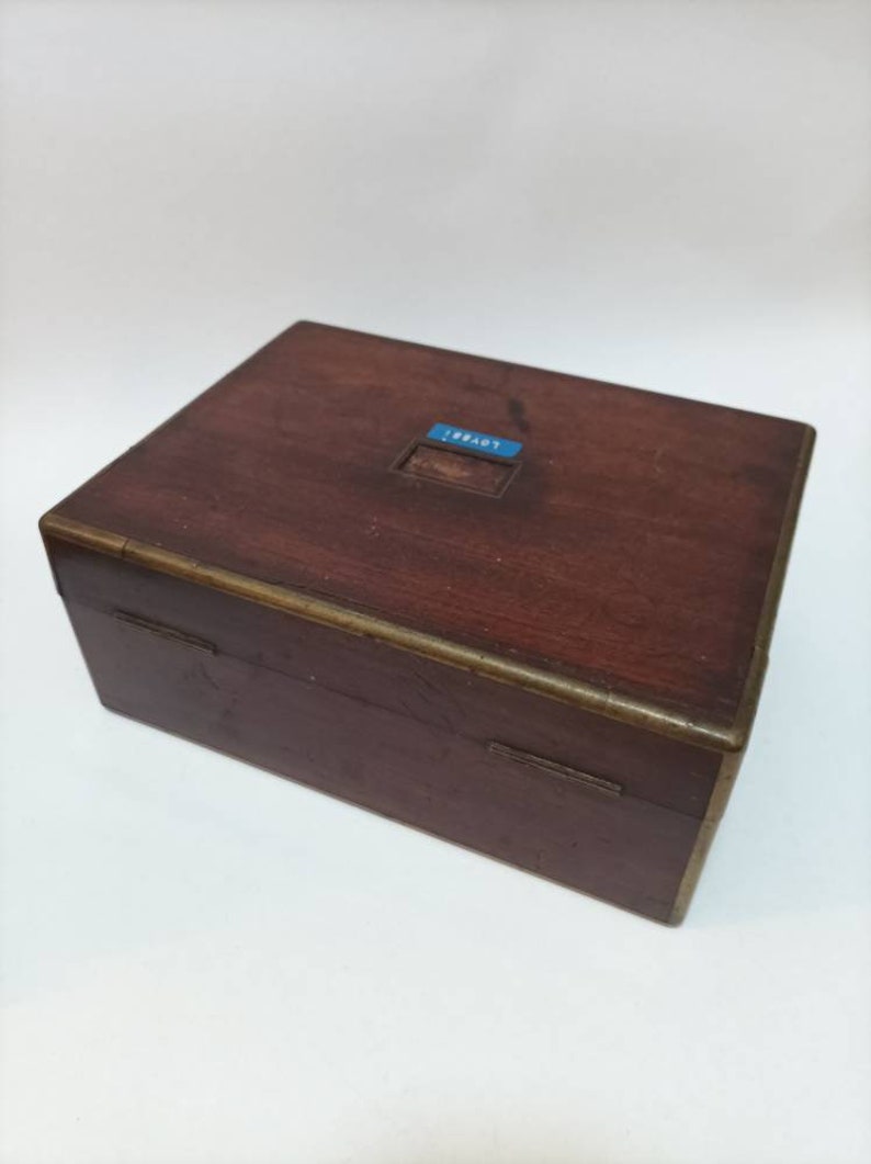 May include: A wooden box with a brass trim and a blue label that says "18847".