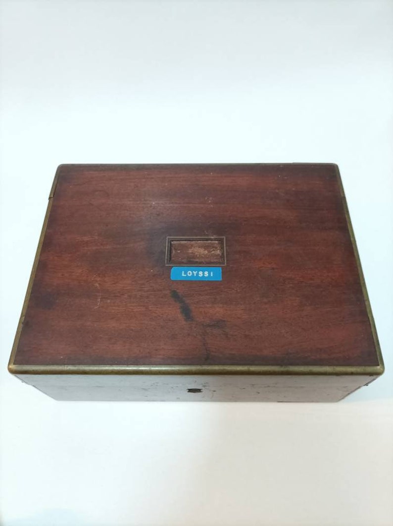 May include: A wooden box with a brass trim and a label that says "LOYSS1".