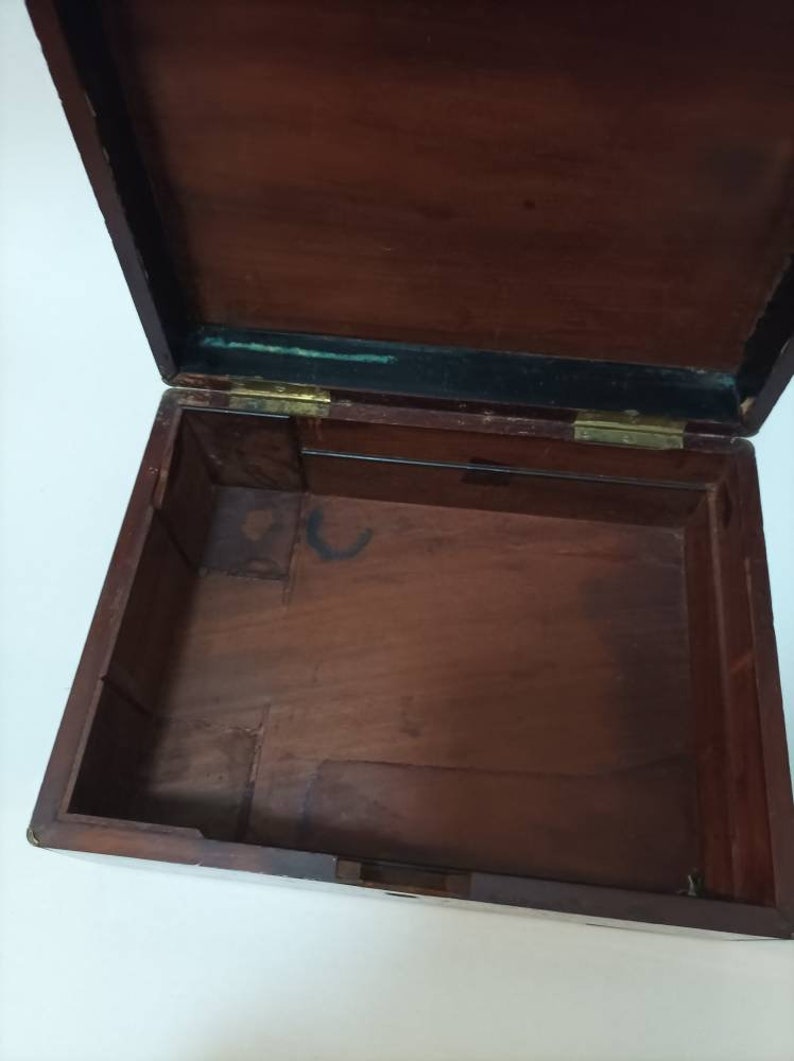 May include: An empty wooden box with a hinged lid. The box is made of dark wood and has a simple design.
