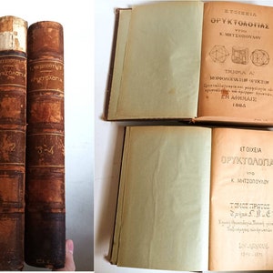 May include: Two antique, brown leather-bound books titled "Stoicheia Oryktologias" by K. Mitsopoulos. The first book is labeled "Tmima A" and the second book is labeled "Tomos Protos".