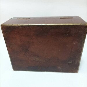 May include: A dark brown wooden box with brass accents. The box has a hinged lid and is closed.