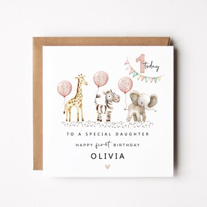 May include: A white card with a brown envelope features watercolor illustrations of a giraffe, zebra, and elephant holding pink balloons. Text reads "To a special daughter, Happy first birthday, Olivia."