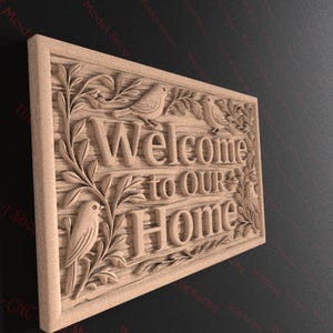 May include: A wooden sign with the words "Welcome to Our Home" carved into the surface. The sign features detailed carvings of birds and foliage, creating a welcoming and rustic aesthetic. The sign is rectangular and made of light-colored wood.