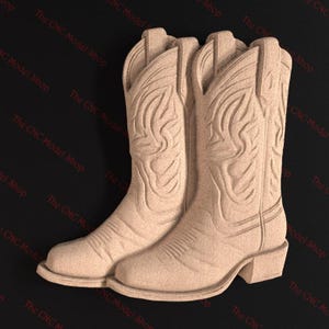 Könnte beinhalten: Ein Paar beigefarbene Cowboystiefel mit aufwendigen Designs, die in das Leder geschnitzt sind. Die Stiefel sind aus einem glatten, strukturierten Material gefertigt und haben eine spitze Zehenpartie.