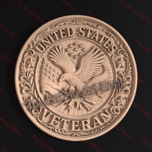 May include: A detailed, circular wooden carving featuring the words "UNITED STATES VETERAN" in a decorative font. The design includes an eagle holding a flag, stars, and intricate floral patterns. The CNC Model Shop logo is visible.