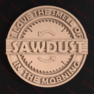 May include: A round wooden sign with the text "I love the smell of sawdust in the morning". The sign features a stylized saw blade with arrows pointing in opposite directions.