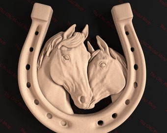 May include: A wooden carving of two horses' heads, facing each other, inside a horseshoe. The carving is a light brown color.