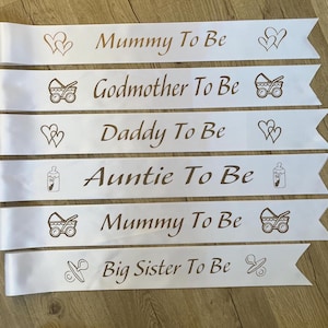 Baby Shower Sash, Mummy To be Sash, Custom sash White sash with gold text. Picture of footprint, Hearts, dummy, Pram, Bottle, Stolk. Personalsised with any wording. Nanny To be, Daddy To Be Big Sister To Be Auntie To Be