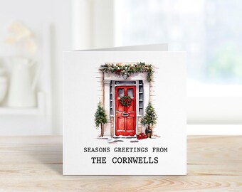 May include: A Christmas card featuring a red door with a wreath and greenery, with the text "Seasons Greetings from The Cornwells".