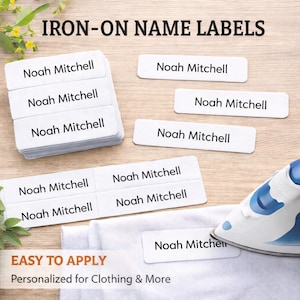 May include: White iron-on name labels printed with the name "Noah Mitchell" in black. The labels are arranged on a wooden surface, alongside an iron and a white cloth. The image also shows the text "IRON-ON NAME LABELS" and "EASY TO APPLY".