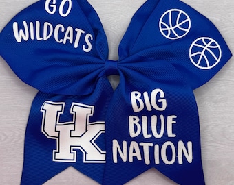 May include: Blue and white cheer bow with the text "Go Wildcats" and "Big Blue Nation" with a basketball graphic and a UK logo.