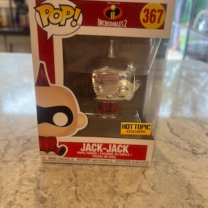 May include: A Jack-Jack vinyl figure from the Incredibles 2 movie, displayed in its original POP! box. The figure has a metallic silver head and red body. The box features the POP! logo, the number 367, and a Hot Topic Exclusive sticker.