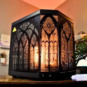 May include: A white ceramic mug with a black handle and the text "But First, Coffee" in a handwritten style. The mug is on a white surface. The mug is likely for hot beverages.