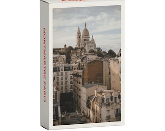 May include: A postcard featuring a photograph of the Sacré-Cœur Basilica in Montmartre, Paris, France. The basilica is a white, domed church with a tall spire. The postcard has the text "MONTMARTRE PARIS" printed on the side.