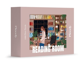 May include: A 1000-piece puzzle box with a pink background. The puzzle image depicts a cozy reading room with bookshelves, a person holding books, and the text "READING ROOM". The brand name "Pieceely" is printed on the box.