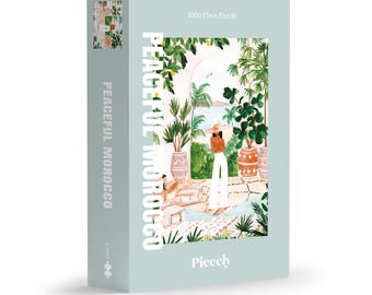 Puede incluir: Un rompecabezas de 1000 piezas que presenta a una mujer con un atuendo blanco de pie en un patio con vegetación exuberante y macetas de terracota. La caja del rompecabezas tiene el texto "Peaceful Morocco" y "Pieceely" en ella.