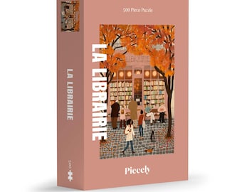 May include: A 500-piece jigsaw puzzle with a pink background. The puzzle features a detailed illustration of a bookstore with people and dogs outside. The words "LA LIBRAIRIE" are printed vertically on the side and front of the box.