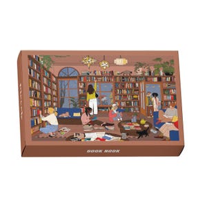 Könnte beinhalten: Eine braune Schachtel mit einer Illustration einer Bibliothek. Das Bild zeigt Menschen, die lesen und Bücher betrachten. Der Text "BOOK NOOK" ist auf der Unterseite der Schachtel aufgedruckt.