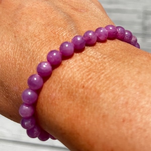 Puede incluir: Un brazalete de piedras preciosas de color púrpura con cuentas redondas.