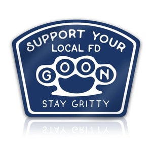 May include: A blue and white sticker with the text "Support Your Local FD Goon Stay Gritty". The sticker features a white knuckle duster graphic.
