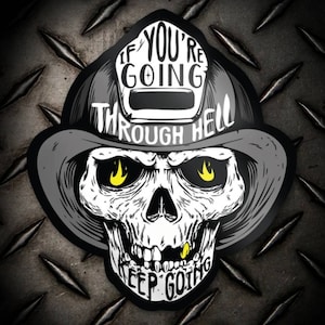 May include: A black and white skull wearing a firefighter's helmet with the text "If you're going through hell, keep going". The skull has yellow flames in its eye sockets.